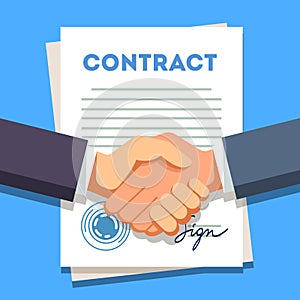 Business man shaking hands over a signed contract photo