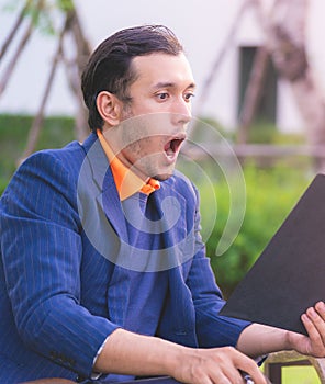 Business man shocking looking at tablet notepad