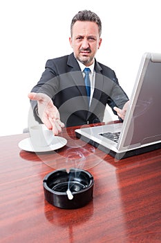 Business man showing cigarette on ashtray at office