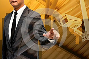 business man showing hand and finger with city light in background double exposure wtih cctv camera