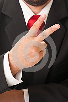 Business man showing number two or peace sign