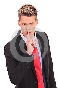 Business man showing silence gesture