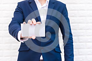 Business man showing white paper. Man  wearing blue suit and holding white blank card. Lifestyle and working concept. Business and