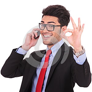 Business man shows ok sign on phone