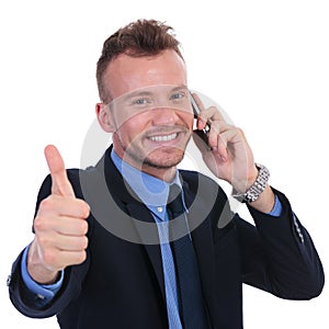 Business man shows thumb up while on phone