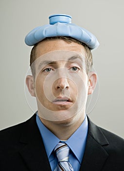 Business man sick with ice pack on head