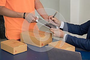 Business man signing documents after receiving goods from deliverer photo