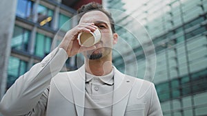 Business man sipping tea looking camera at city portrait. Leader enjoying coffee