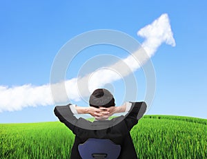 Business man sit on chair and watch growth cloud