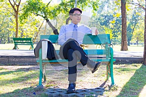 Business man,He is sitting on bench in park.He is thinking about business.