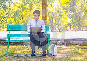 Business man,He is sitting on bench in park.He is thinking about business.