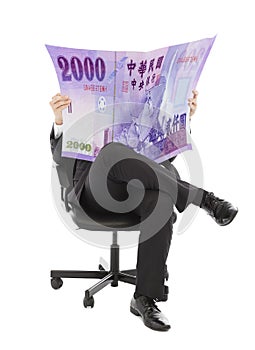 Business man sitting on a chair with taiwan currency in hands