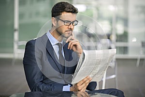 Business man sitting at coffee shop with a newspaper