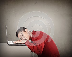 Business man sleeping in front of his laptop