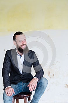 Business man smile sitting shabby wall background
