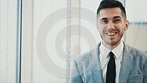 Business man smiles sincerely, looking at the camera, isolated on white blurred background. Close up. Copy space. 4K.