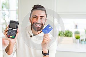 Business man smiling and holding point of sale terminal and credit card, contacless transaction