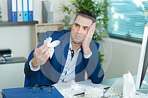 business man with sneezing in tissue in hand