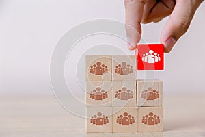 Business man stacking wooden team blocks at table for team management concept or human resource planning
