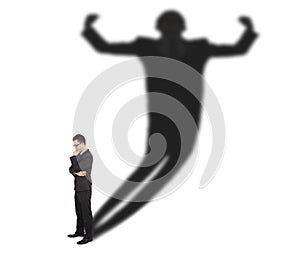 Business man standing and casting shadow of a strong man