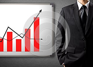 Business man standing and drawing growth chart on white board