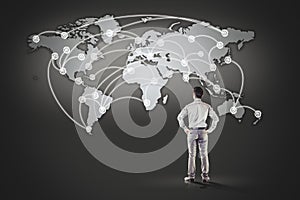 Business man standing in front of world map