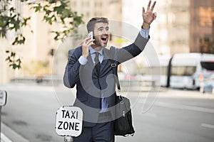 Business man standing hailing a taxi cab in the city photo