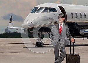 Business man standing next to a private jet