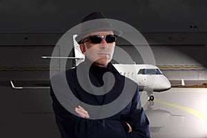 Business man standing next to private jet