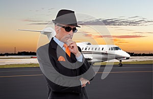 Business man standing next to private jet