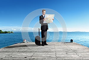 Business man standing on pier whith map