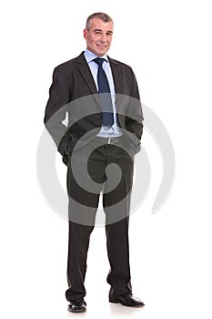 Business man stands with hands in pockets