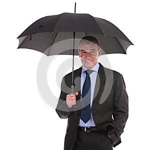 Business man stands under umbrella