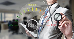 Business man with stethoscope examining risk