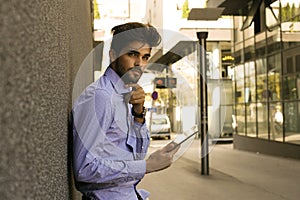 Business man on street using iPod.