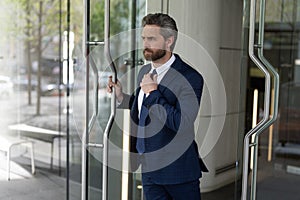Business man. Successful businessman entering office. Adult entrepreneur at office door. Hispanic businessman in suit