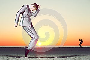 Business man in suit dancing at the beach. photo