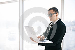 Business man in suit and eyesglasses with laptop