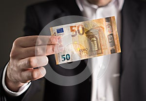 Business man in suit holding 50 euro banknote