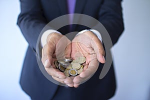 Business man in a suit holding Peruvian coins, Nuevos Soles currency concept photo