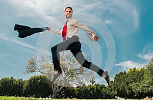 Business man in suit jumping over urban park. Fast business concept.