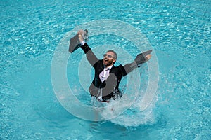 Business man in suit with laptop excited jumping in swimming pool. Funny businessman in suit with computer laptop on the