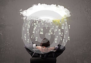 Business man in suit looking at cloud with falling money