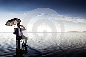 A business man in a suit with an umbrella