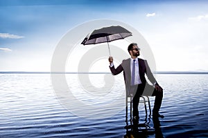 A business man in a suit with an umbrella