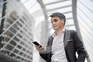 Business man in suit using smartphone in city