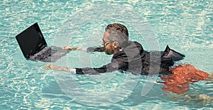 business man on summer vacation. businessman in wet suit in swim pool. Remote working. Summer business dreams