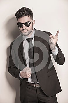 Business man with sunglasses pointing his finger