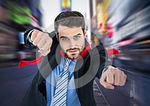 Business man superhero with hands out against blurry street