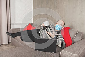 Business man in surgical medical virus protection mask working at home